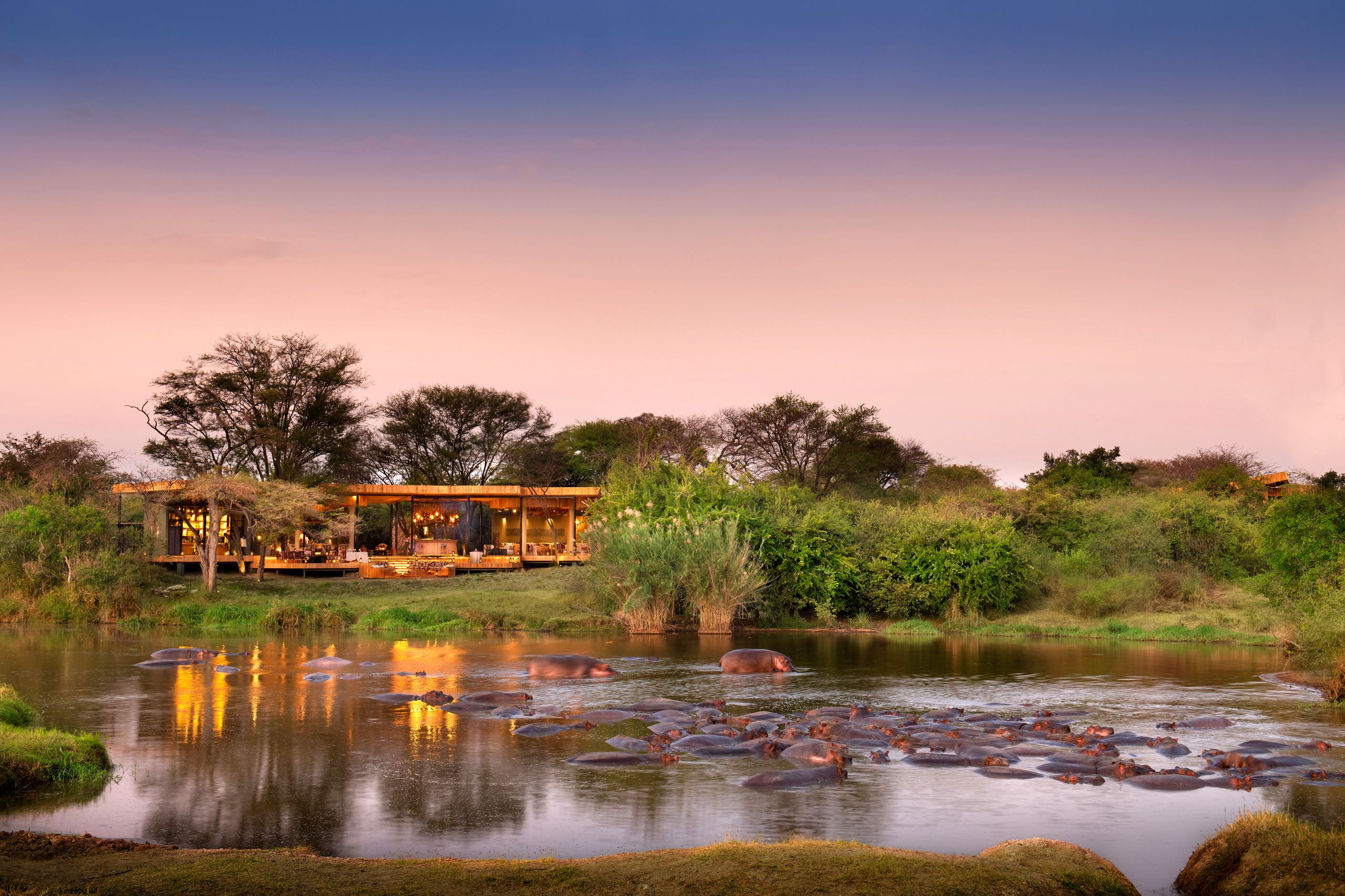 A lodge deck looking out over a river at sunset